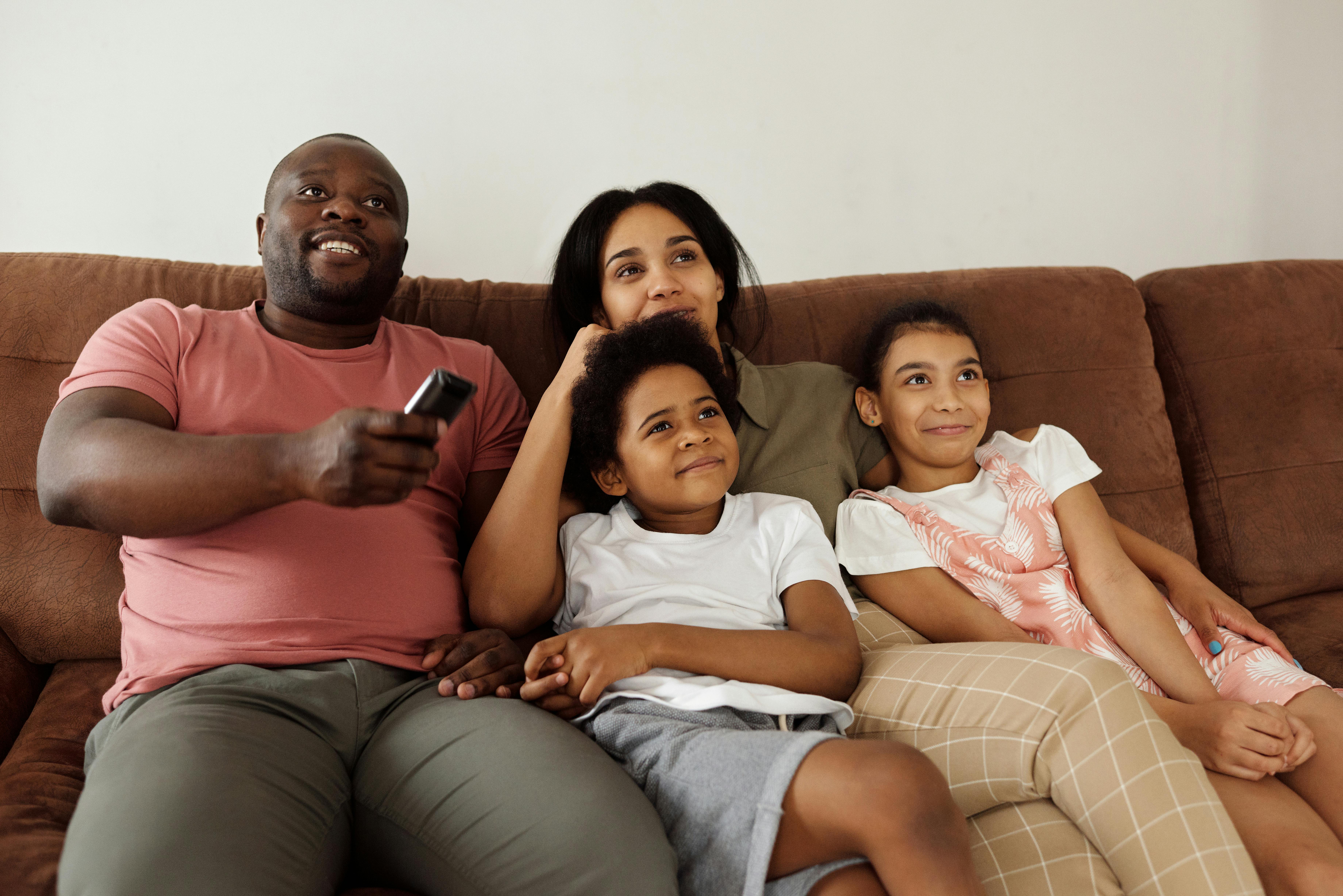 A young family sat on a sofa